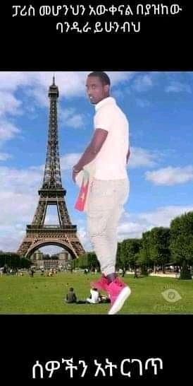 a man in white pants and pink shoes standing in front of the eiff tower